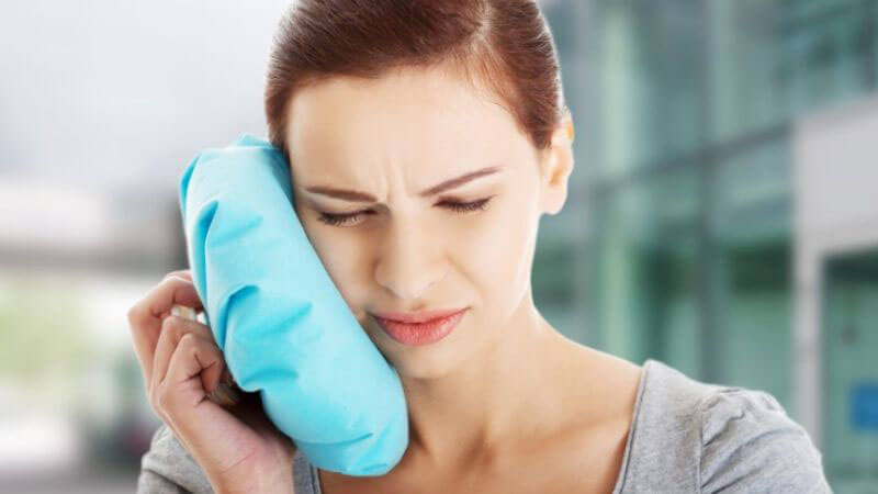 Chườm khăn lạnh là cách hỗ trợ tạm thời giúp trong thời gian chờ đến nha khoa
